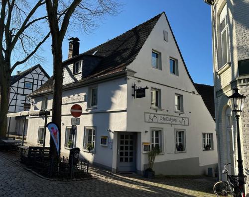 un edificio blanco en la esquina de una calle en Pension Café Eisgold, en Ratingen