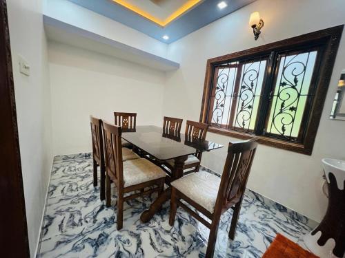 a dining room with a table and chairs and a window at Small town villa in Mapusa