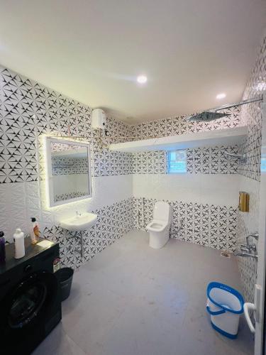 a bathroom with a white toilet and a sink at Small town villa in Mapusa