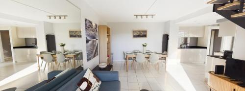 un salon avec un canapé bleu et une salle à manger dans l'établissement Duplex terrasse place du Marché, à La Baule