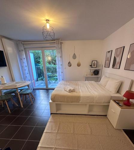 - une chambre avec un grand lit, une table et une table dans l'établissement Nina-Studio, à Strasbourg