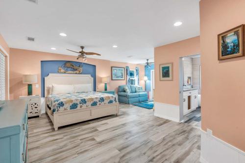 Un dormitorio con una cama y una silla azul. en Heated Pool & Spa Home on a Scenic, Gulf Access Canal -Close to Bonita Beach!, en Bonita Springs