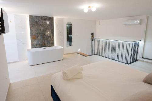 a white room with a bed and a bath tub at Dimora in Cortile in Manfredonia
