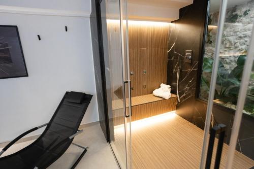 a glass shower with a black chair in a room at Dimora in Cortile in Manfredonia