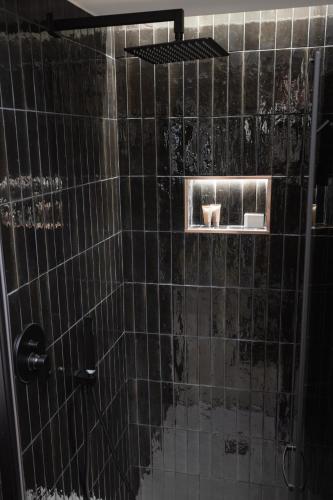 a bathroom with a black tiled shower with a sink at Dimora in Cortile in Manfredonia