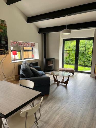 a living room with a couch and a table at Richmond Hill Cottage Markington in Ingerthorpe