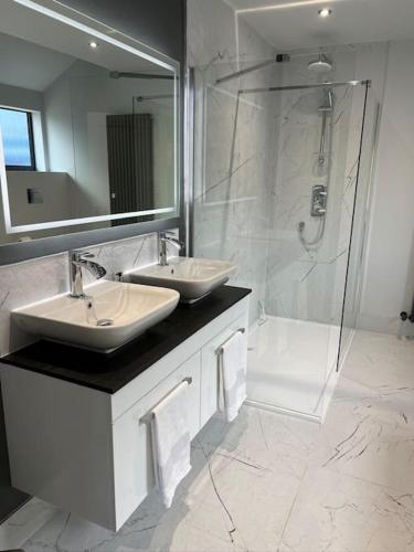 a bathroom with two sinks and a shower at Richmond Hill Cottage Markington in Ingerthorpe