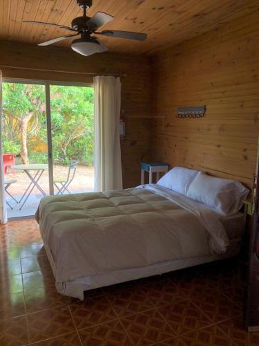 a bedroom with a bed and a large window at Las Alqui millas Apart in Punta Del Diablo