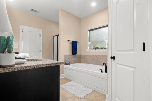 a white bathroom with a tub and a sink at Tailored For Work Groups At Thibs Crib in Lake Charles