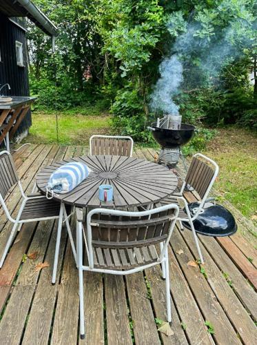an outdoor table and chairs with a grill and a barbecue at Summer House Close To The Sea On North Langeland in Tranekær