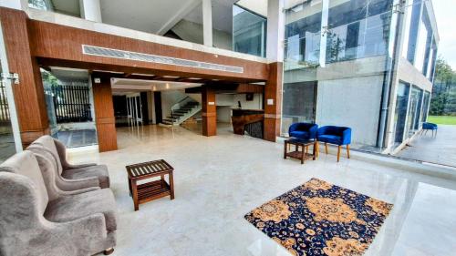 a lobby of a building with chairs and a rug at Mango Retreat Bhopal in Bhopal