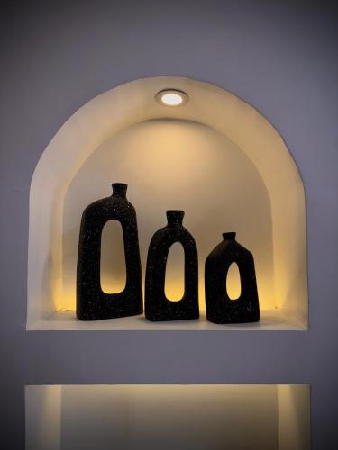 three black vases are sitting on a shelf at Dar Lina Guesthouse Luxor in Luxor