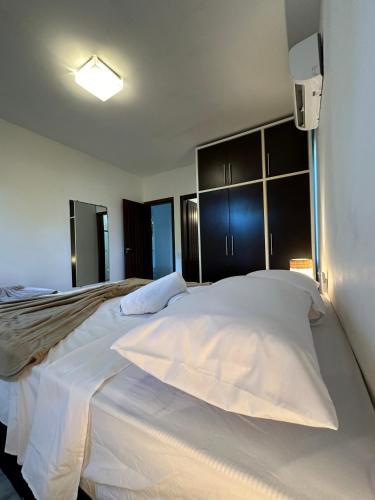 a bedroom with a large white bed in a room at Casa Mar Arraial d'Ajuda in Arraial d'Ajuda