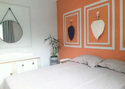 a bedroom with a white bed and a mirror at Recanto do sossego!! in Morretes