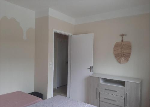 a white bedroom with a bed and a mirror on the wall at Recanto do sossego!! in Morretes