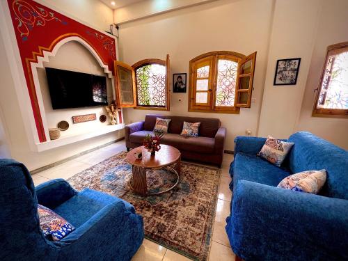 a living room with two blue couches and a table at Dar Lina Guesthouse Luxor in Luxor