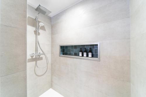 La salle de bains est pourvue d'une douche et de 3 bouteilles de vin. dans l'établissement Le Grand Lion Colmar Centre Parking Gratuit, à Colmar