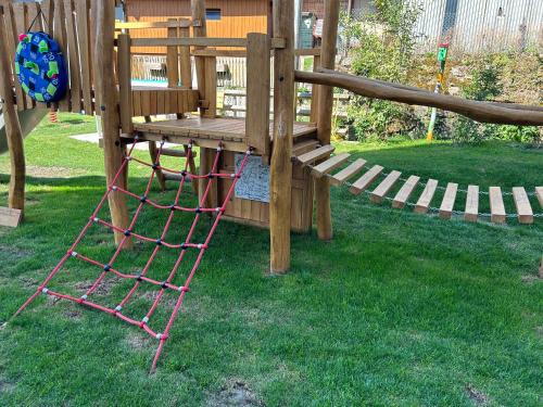a wooden playground with a ladder on the grass at Gengs Linde in Stühlingen