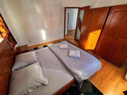 a large bed in a bedroom with two pillows on it at Casa Kolbert in Borsec