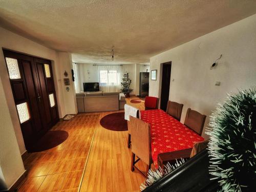 a living room with a red couch and wooden floors at Casa Kolbert in Borsec