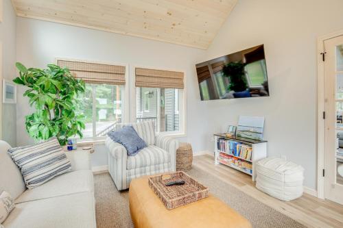 a living room with white furniture and a tv at Lakefront Rhinelander Cottage with Private Dock! in Rhinelander