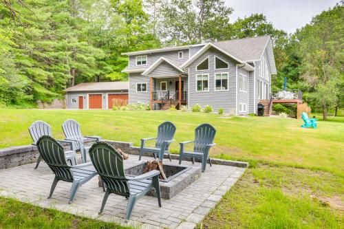 a group of chairs sitting on a patio in front of a house at Lakefront Rhinelander Cottage with Private Dock! in Rhinelander