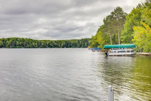 a dock with a boat on a lake at Lakefront Rhinelander Cottage with Private Dock! in Rhinelander