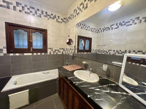 a bathroom with a sink and a bath tub and a sink at Villa familiale Achakkar 2 in Tangier