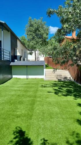a yard with a building and a green garage at Monrepos Cercedilla in Cercedilla