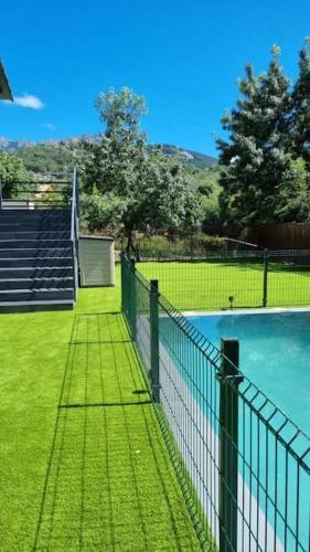a fence next to a swimming pool with some stairs at Monrepos Cercedilla in Cercedilla
