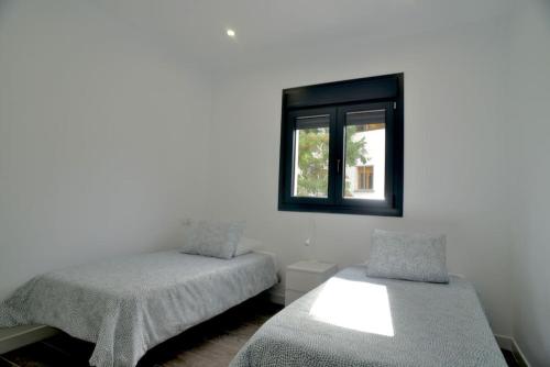 a bedroom with two beds and a window at Monrepos Cercedilla in Cercedilla