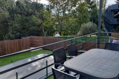 a patio with a table and chairs on a balcony at Monrepos Cercedilla in Cercedilla