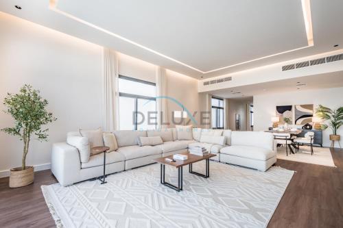 a living room with a white couch and a table at Special Offer with BBQ, Pool Perfect for Groups by Deluxe Holiday Homes in Fujairah