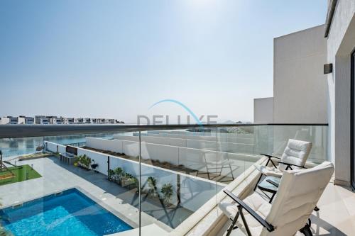 a balcony with a swimming pool on a building at Special Offer with BBQ, Pool Perfect for Groups by Deluxe Holiday Homes in Fujairah