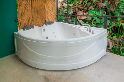 a white bath tub sitting in front of a wall at Arenal Getaway in Fortuna