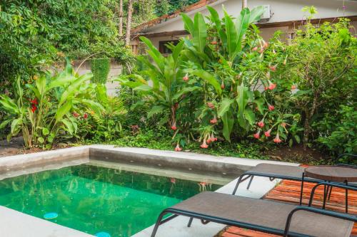 a pool with a table and chairs next to some plants at Arenal Getaway in Fortuna
