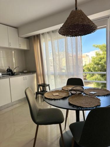 a kitchen with a dining table with chairs and a tableablish at T2 Centro cidade in Mindelo