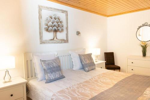 a bedroom with a bed with pillows and a picture on the wall at Villa Sol Nudist Place in Charco del Palo