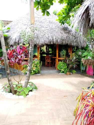 a house with a straw roof with a patio at Cabañas Riviera Pacific in Pedernales