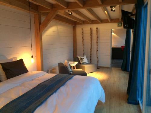 una camera con letto, sedia e tavolo di Bed and Breakfast Art a Zedelgem