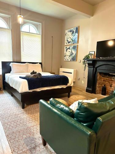 a bedroom with a bed and a couch and a fireplace at Newly renovated apartment in the heart of Detroit! in Detroit