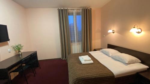 a hotel room with a bed and a window at Belfort- Łomża in Łomża