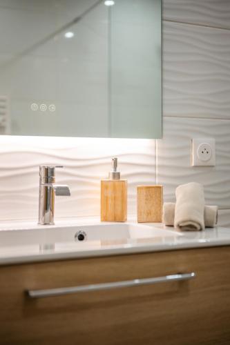 a bathroom counter with a sink and a mirror at Appartement bord de mer « La Petite Ma-Line » in Cagnes-sur-Mer