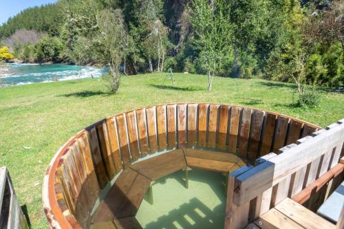 a wooden bucket filled with water next to a field at Huequecura Explorer in Quilaco