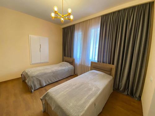 een slaapkamer met twee bedden en een raam bij Surami Comfort House in Surami