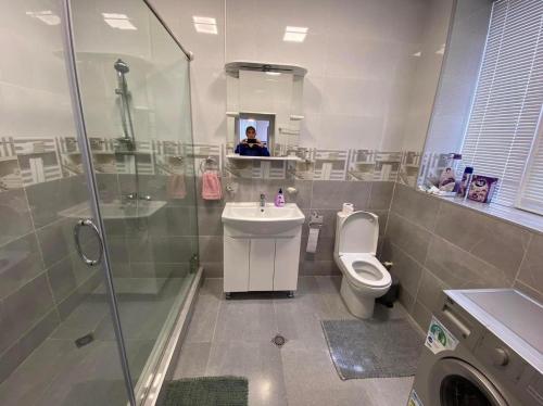 een badkamer met een toilet, een wastafel en een douche bij Surami Comfort House in Surami