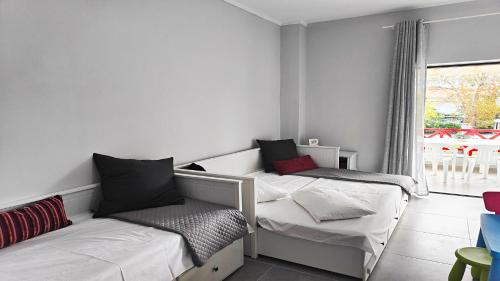 twee bedden in een kamer met een raam bij Hanioti Beach Front Apartments in Hanioti