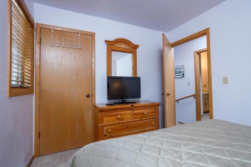 a bedroom with a bed and a television on a dresser at Peacefield at The Hilltop C-4 by Simple Life Rentals in Fish Creek