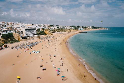 a group of people on a beach with the ocean at Apt 164 - Vila Galé Cerro Alagoa in Albufeira