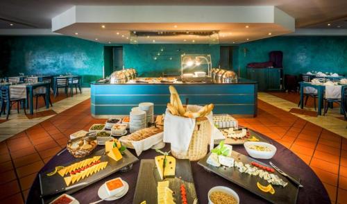 a buffet line with food on a table in a restaurant at Apt 164 - Vila Galé Cerro Alagoa in Albufeira